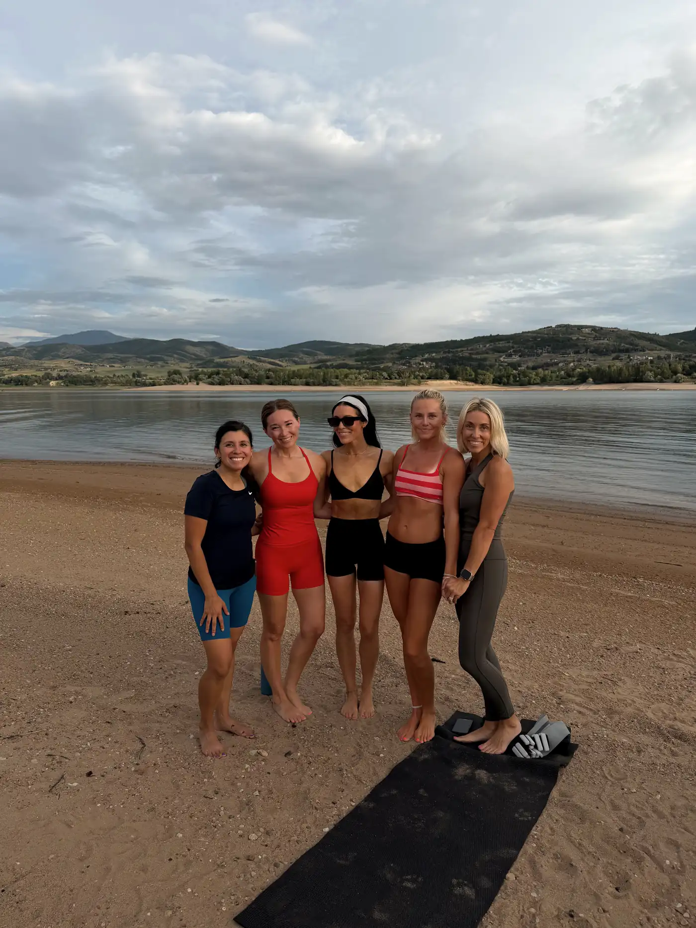 An Origin class gathered on the beach at golden hour